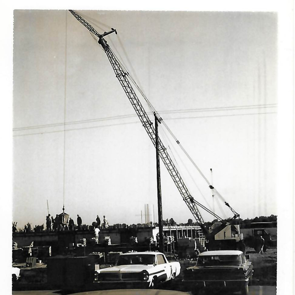 Large crane in front of 1940s vehicles